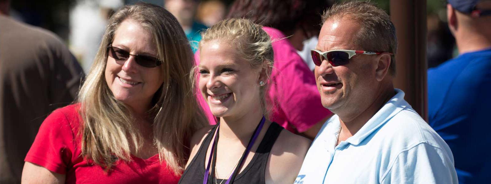 mom, dad, 和 student pose for picture on move-in day