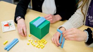 close up of students' hands as they work with math manipulative blocks