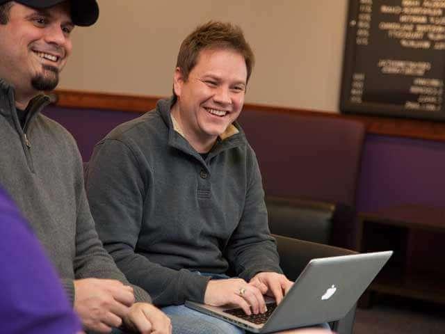 Adult male student works on laptop